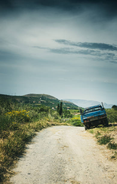 istock Dirt road and agricultural field 1176842800