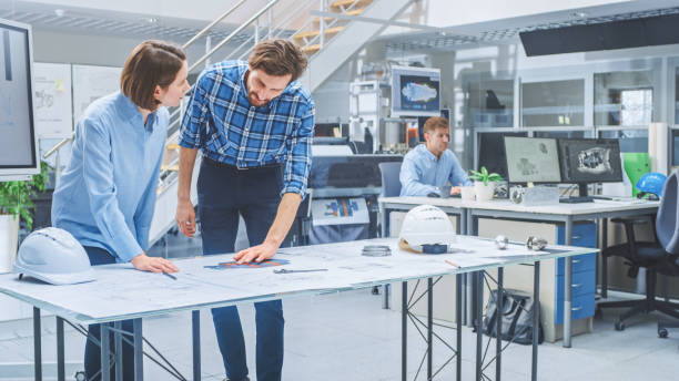 istock In the Busy Engineering Agency: Diverse Group of Engineers, Technicians, Specialists Working on Design for Industrial Engine Prototype. Professionals Talk, Work with Drawings, Use Computers 1176842818