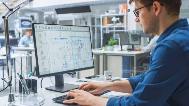 au-dessus de la prise de vue d'épaule de l'ingénieur travaillant avec le logiciel de cao sur l'ordinateur de bureau, l'écran affiche les projets techniques et les dessins. dans l'installation d'ingénierie de fond spécialisée dans le design industriel - engineer photos et images de collection