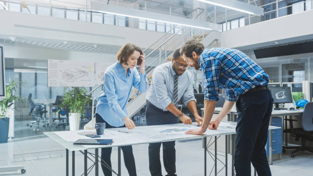 istock In the Industrial Engineering Facility: Two Architects and Chief Engineer, Discuss and Analyse Industrial Engine Prototype Drafts Using Conference Table. 1176842860