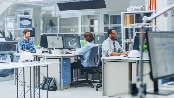 istock In the Busy Engineering Facility: Diverse Group of Engineers, Technicians, Specialists Working on Design for Industrial Engine Prototype. Professionals Talk, Work with Drawings, Use Computers 1176842964