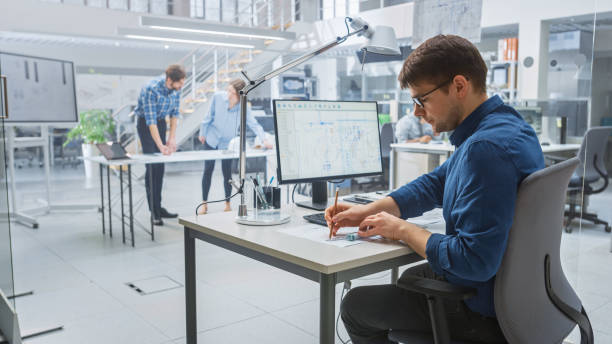 istock In the Busy Engineering Facility: Diverse Group of Engineers, Technicians, Working on Design for Industrial Engine Prototype. Specialists Talk During Meetings, Work with Drawings, Use Computers 1176843576