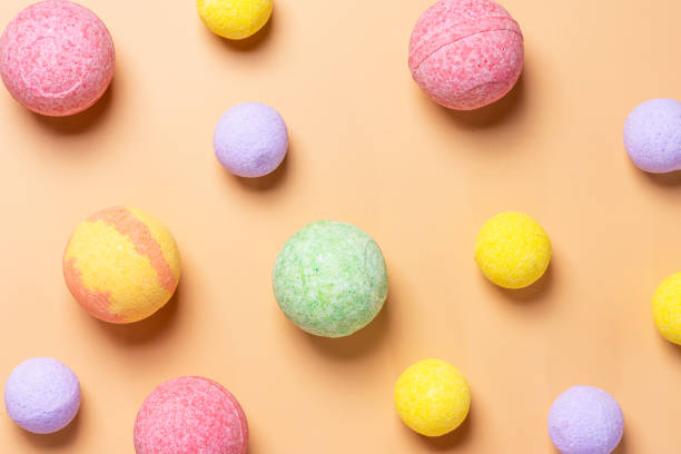 Colorful bath bombs on a pastel orange background