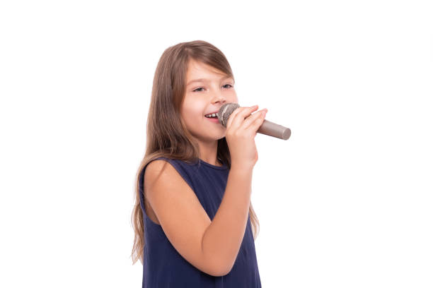 istock Little girl posing with a microphone for singing on white background. 1176846070
