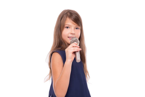 istock Little girl posing with a microphone for singing on white background. 1176846071