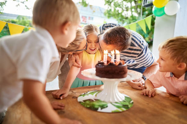 Happy birthday baby Shot of a beautiful family celebrating daughter's birthday, parents kissing her with brothers standing by birthday wishes for daughter stock pictures, royalty-free photos & images
