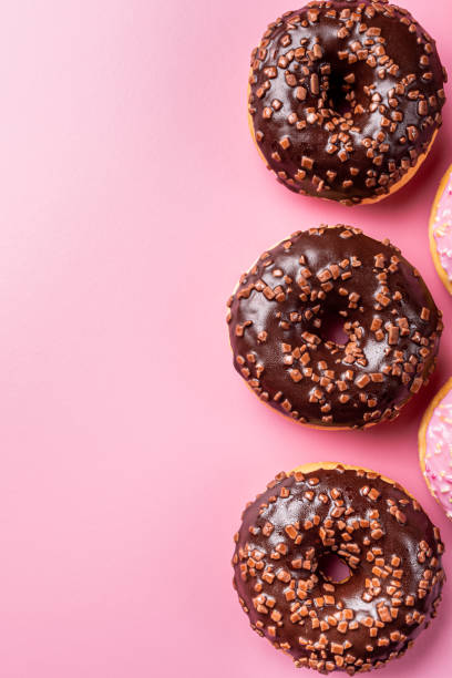 istock Colorful donuts on rose background 1176846897