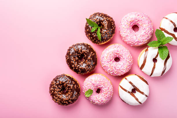 istock Colorful donuts on rose background 1176846900
