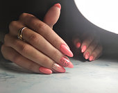 Long round pink fingernails. Gel Polish with design geometric lion and gradient silver sprinkles