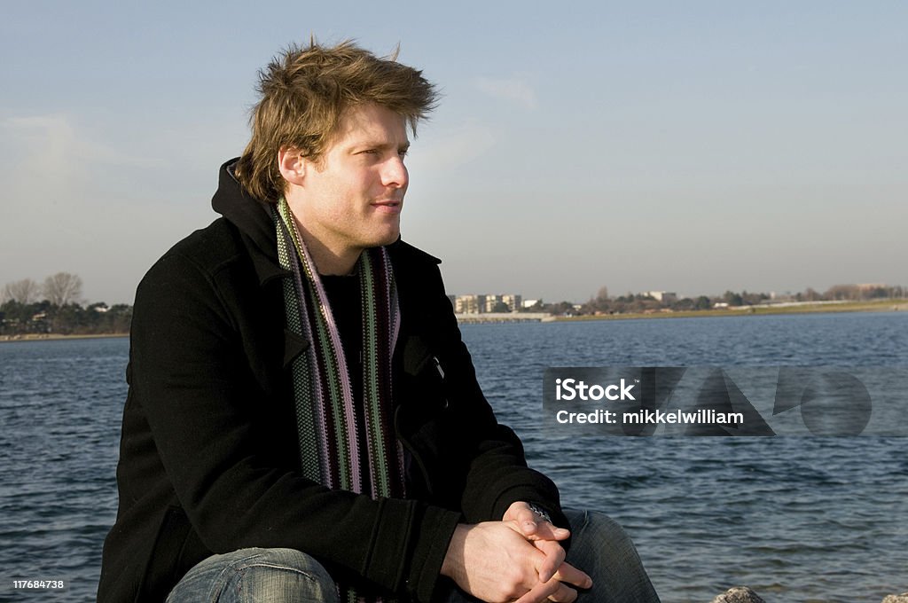 Happy mans sits comfortable at the sea with hands folded  30-34 Years Stock Photo