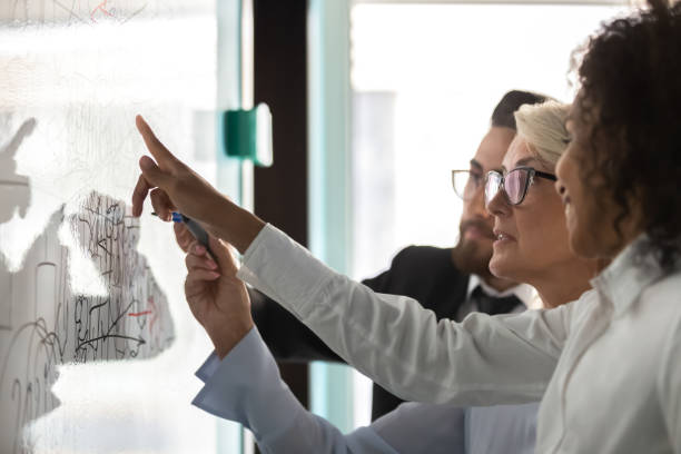 close up diverse colleagues drawing on flip chart, brainstorming - writing whiteboard men businessman imagens e fotografias de stock