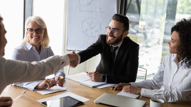 istock Smiling businessmen handshaking at business briefing, making agreement 1176848621