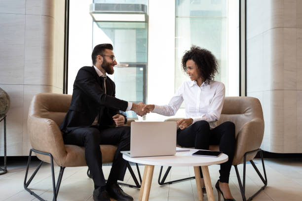 istock Smiling diverse business partners shaking hands at meeting 1176848646
