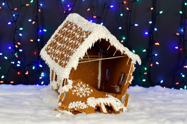 istock The crashed hand-made eatable gingerbread house, snow decoration, garland background illumination 1176848789
