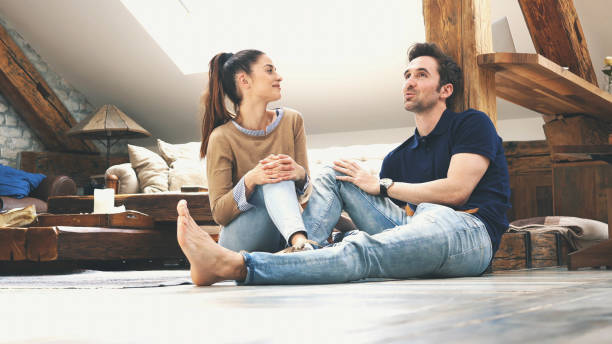 istock happy couple talking to each other at home 1176848851