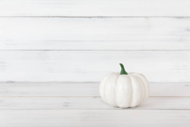 istock White pumpkin on white wood table with copy space. 1176851568