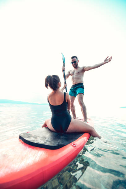 istock Handsome Male Showing His Girlfriend His Favorite Hobby - Paddle boarding 1176854335