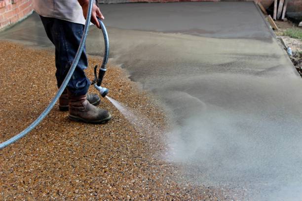 istock Construction Worker Washing Concrete to Get an Exposed Aggregate Finish on Concrete 1176855013