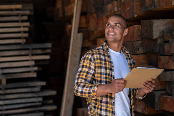 Young male worker in timber warehouse