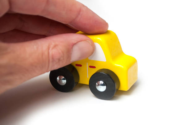 istock miniature wooden car in hand on white background 1176858058