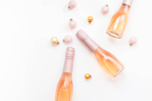 бутылки розового шампанского на белом фоне - champagne pink bottle isolated стоковые фото и изображения