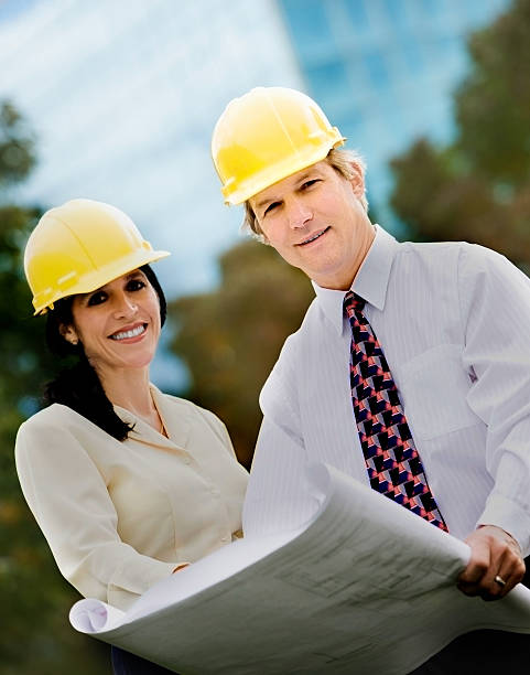 istock Architects Wearing Hardhats Looking at Drawings 117686155