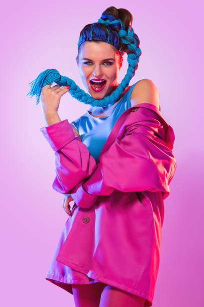 Stylish woman in pink and blue clothes Stylish woman in colorful clothes with threads in her tail over pink background womens blue suede shoes stock pictures, royalty-free photos & images