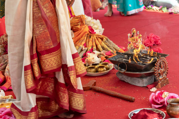 istock Indian wedding ceremony, decorations for traditional ethnic rituals for marriage, fire burning, flowers and statuettes of the deity on red carpet 1176864768