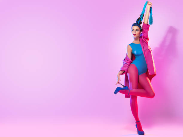 Stylish woman in pink and blue clothes Stylish woman in colorful clothes with threads in her tail over pink background womens blue suede shoes stock pictures, royalty-free photos & images
