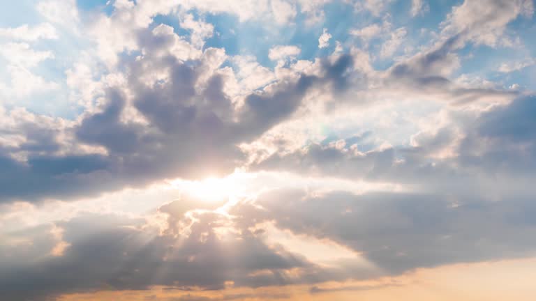 Timelapse: sun beams shining through moving dramatic white clouds - hope concept