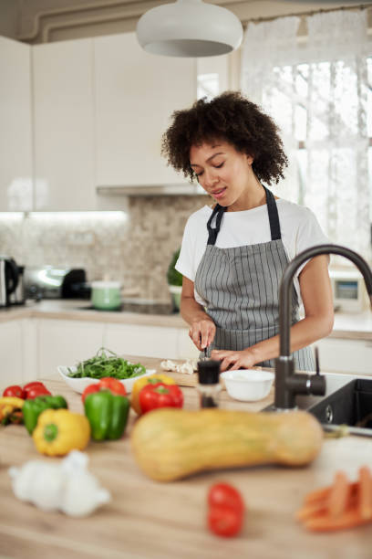 istock Mixed race housewife chopping mushrooms. 1176867155