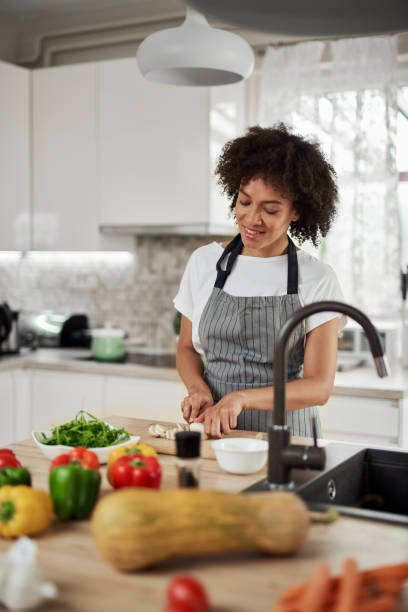 istock Mixed race housewife chopping mushrooms. 1176867209