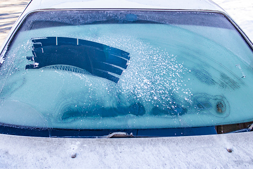 cleared the frost on the windshield in the cold, front and rear blurring the background