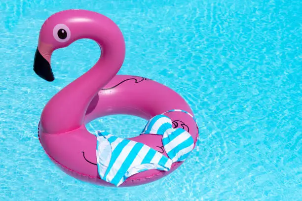 Pink flamingo inflatable in a swimming pool with a bikini