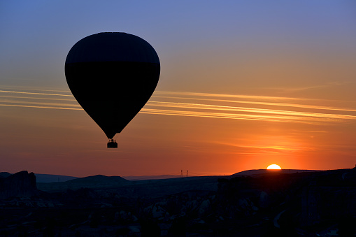 Stunning morning view and balloons in Cappadocia taking off at sunrise. Every day over 100 balloons fly taking tourist on a magical view of Nevsehir.