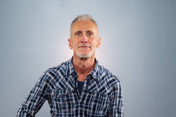 istock Confident senior man with blue plaid shirt studio portrait 1176876180