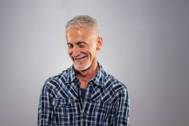 istock Shy senior man looking down smiling studio portrait 1176876188