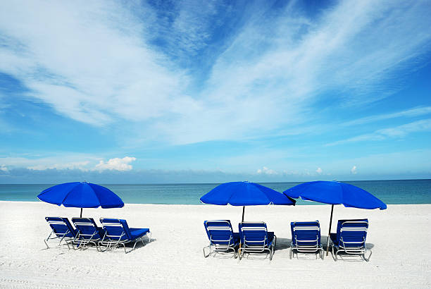 istock Blue lounge chairs and sun umbrellas on a white sand beach 117687669