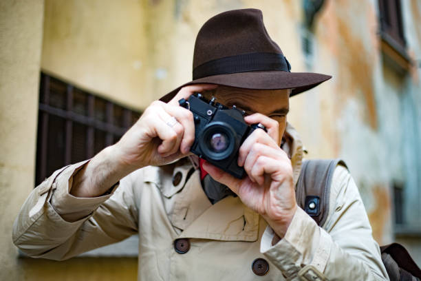 istock Detective taking pics in a sity slum with his vintage camera 1176884360