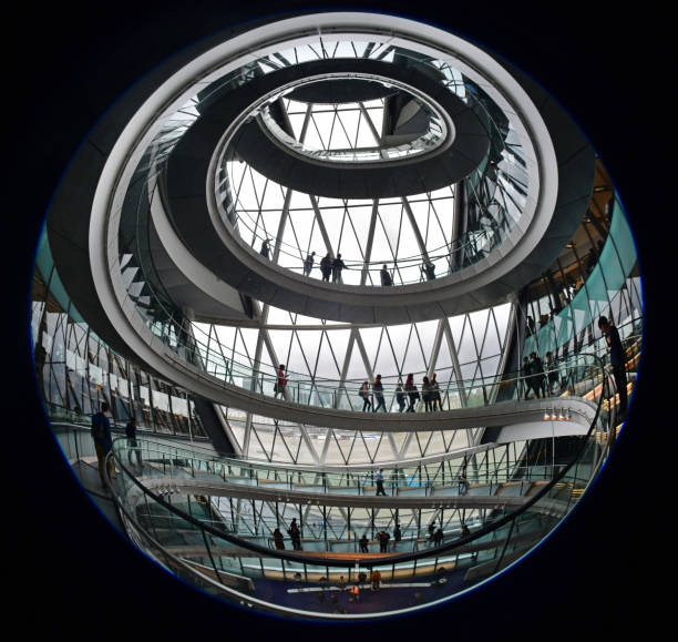 London architecture Abstract Fish Eye of London City Hall’s public helical spiral ramp/staircase - silhouettes of Londoner's and tourist descending the staircase above the city council chamber and offices of the Mayor of London fish eye lens photos stock pictures, royalty-free photos & images