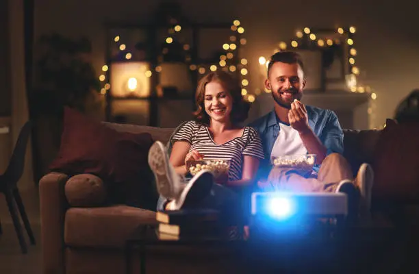 Family couple watching television at home on the sofa