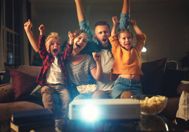 家族の母の父と子供は、自宅で夕方にポップコーンと映画、テレビ、映画を見て - 11905 ストックフォトと画像