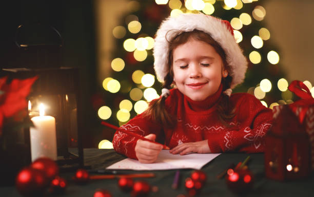 criança menina escrevendo carta santa casa perto de árvore de natal - 11902 - fotografias e filmes do acervo
