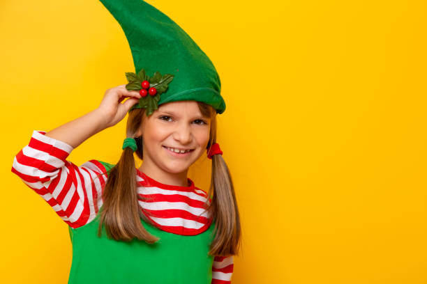 istock Child wearing elf costume holding mistletoe 1176894820