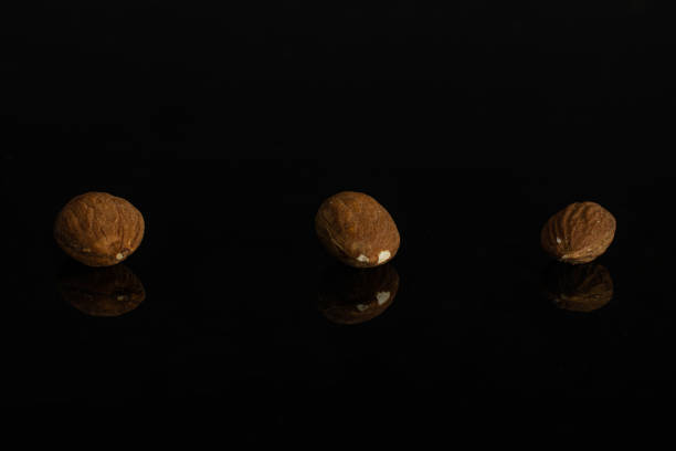 istock Brown almond nut isolated on black glass 1176896197