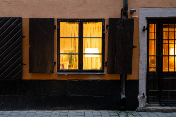 typical house at dusk Stockholm, Sweden. September 2019.  the illuminated window of a typical house at dusk in the city center stortorget photos stock pictures, royalty-free photos & images