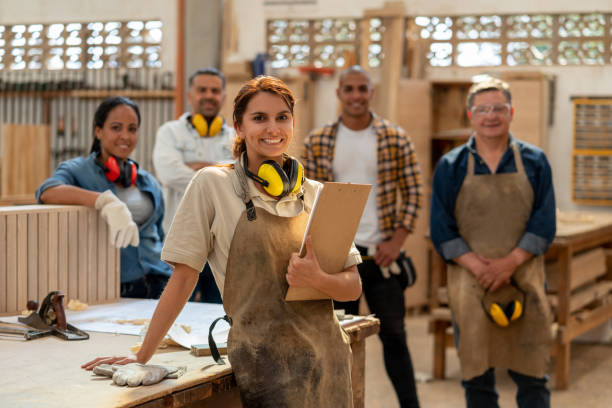 istock Woman with a group of workers working at a carpentry 1176900037