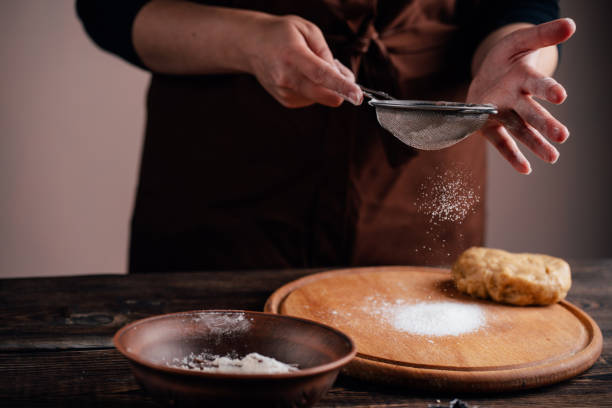 istock Woman sprinkling flour on gingerbread dough 1176901679