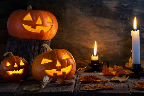 istock Three Halloween pumpkins head jack o lantern on wooden table background 1176903021