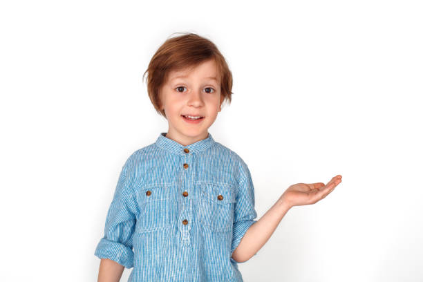 istock Boy studio standing isolated on grey showing space aside looking camera surprised 1176906906